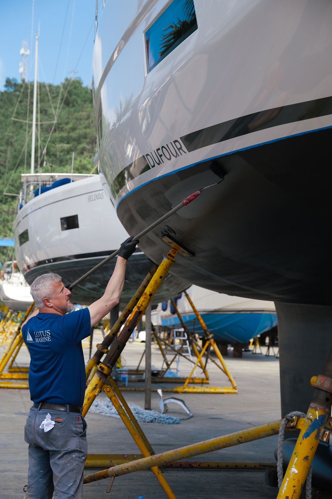 Lotus Marine ustası, karadaki bir teknenin pervanesinde bakım yapıyor